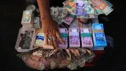A hand hovers over cash