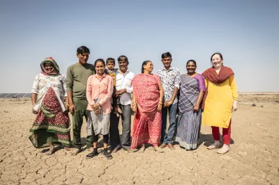 A group of people stands in a dry field in India