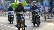 Vietnamese vendors ride on motorbikes with goods