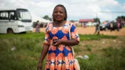 a smiling African woman in a colorful dress