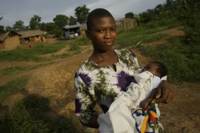 A young African woman holds a baby