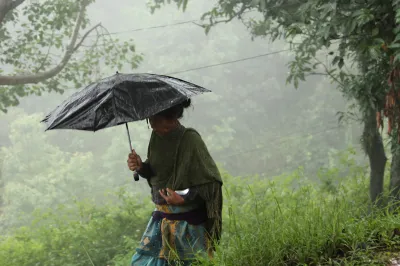A woman walks with an umbrella in rural Nepal