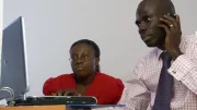 Business colleagues review information on a computer screen.