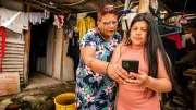 Two women look at a smartphone
