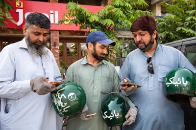Gig workers in Pakistan look at their smartphones