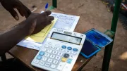 An employee for an MFI in Mali does paperwork.