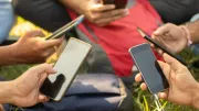 a group of people in a circle hold smart phones