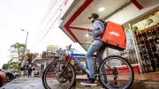 a delivery man on a bike looking at his phone