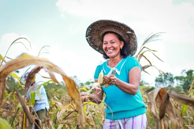 A woman farmer in the Philippines smiles in her field