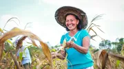 A woman farmer in the Philippines smiles in her field